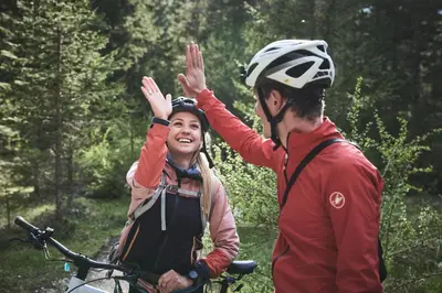 a woman is giving a man a high five at AMA Stay in San Vigilio Di Marebbe