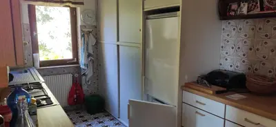 a kitchen with a white refrigerator and a window at Villa for a get away in Soprabolzano