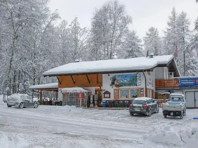 a gas station with cars parked in the snow at Albergo Pineta in Castello di Fiemme