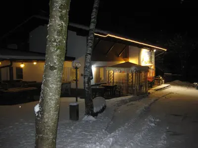 a house in the snow at night at Albergo Pineta in Castello di Fiemme
