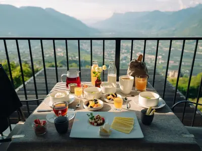 a table with food and drinks on top of a balcony at Culinaria living in Tirolo