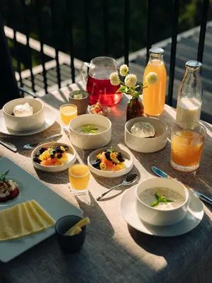 a table with plates of food and glasses of orange juice at Culinaria living in Tirolo