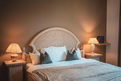 a bedroom with a large bed with two lamps at Majestic Apartment by Majestic Resorts Dolomites in Riscone
