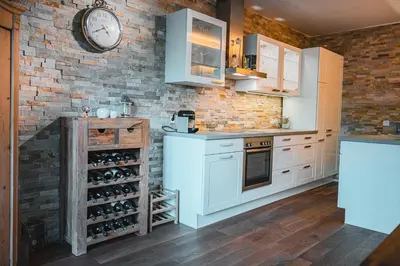 a kitchen with a clock on a brick wall at Majestic Apartment by Majestic Resorts Dolomites in Riscone