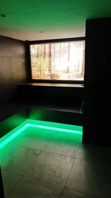 a dark room with a window with green lighting at Laurena Aparthotel in Naz-Sciaves