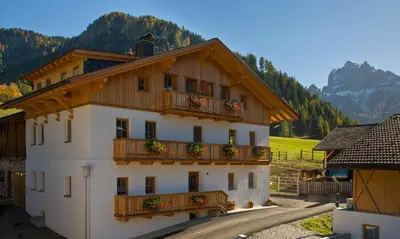 a building with flowers on the balconies of it at Appartments Jagerhof in Braies