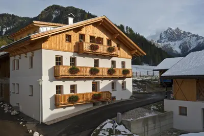 a building with a balcony with flowers on it at Appartments Jagerhof in Braies