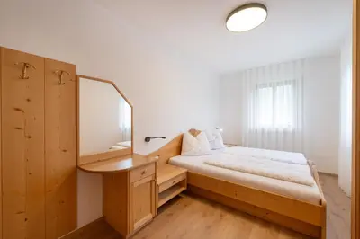 a bedroom with a bed and a mirror at Marolhof in Cornaiano