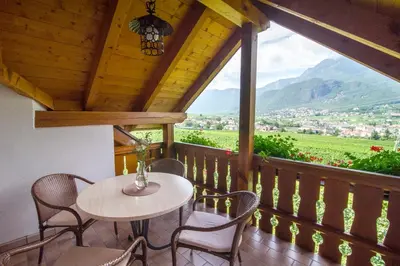 a table and chairs on a balcony with a view at Marolhof in Cornaiano