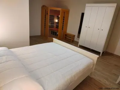 a bedroom with a large white bed and a closet at Pordoi H10 - with SAUNA in Alba di Canazei