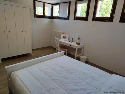 a bedroom with a bed and a desk and windows at Pordoi H10 - with SAUNA in Alba di Canazei