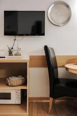 a black chair sitting next to a desk with a tv at Luggishof in Campo Tures