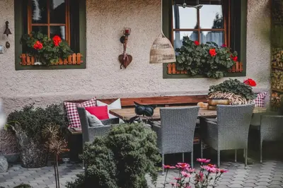 a patio with a table and chairs and flowers at Luggishof in Campo Tures