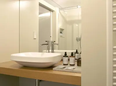 a bathroom with a white sink on a wooden counter at Marktplatz 10 in Caldaro