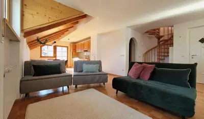 a living room with two couches and a staircase at Apartment Frisch in San Lorenzo di Sebato