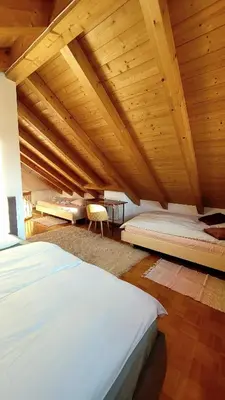 a large room with two beds and a wooden ceiling at Apartment Frisch in San Lorenzo di Sebato