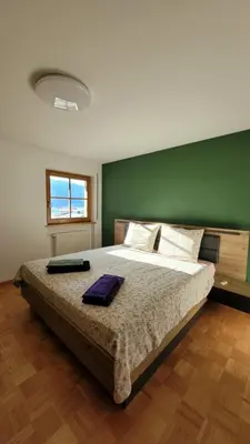 a bedroom with a large bed with a green wall at Apartment Frisch in San Lorenzo di Sebato