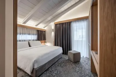 a hotel room with a large bed and a window at Hotel Lajadira & Spa in Cortina dʼAmpezzo