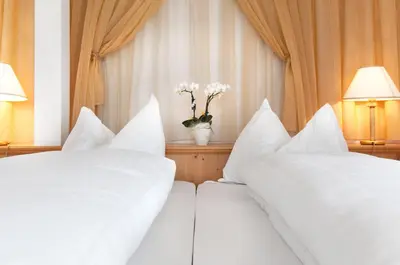 two beds in a hotel room with white pillows at Hotel Rotwand in Laives