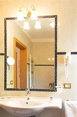 a bathroom with a sink and a large mirror at Hotel Rotwand in Laives