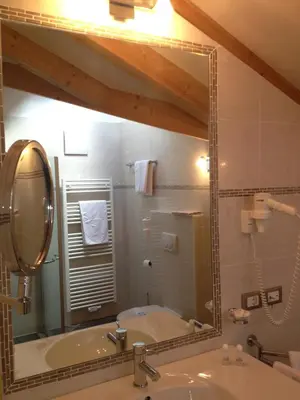 a mirror in a bathroom with a sink and a tub at Hotel Rotwand in Laives