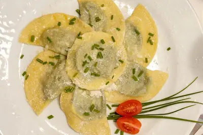 a plate of ravioli with a tomato on it at Hotel Rotwand in Laives