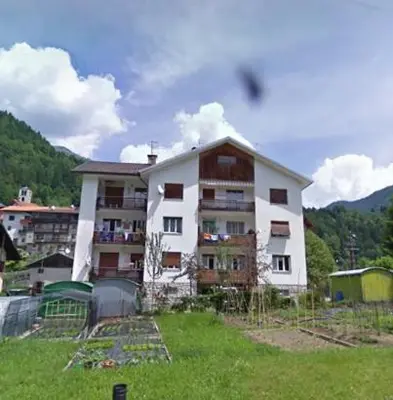 a large apartment building in the middle of a field at Appartamento Vanoi nel cuore verde del Trentino in Canale San Bovo