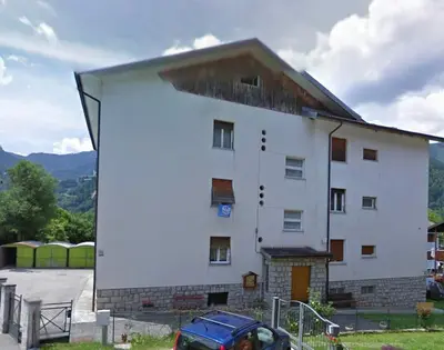 a building with a car parked in front of it at Appartamento Vanoi nel cuore verde del Trentino in Canale San Bovo
