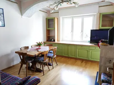 a kitchen with green cabinets and a wooden table at Appartamento Vanoi nel cuore verde del Trentino in Canale San Bovo