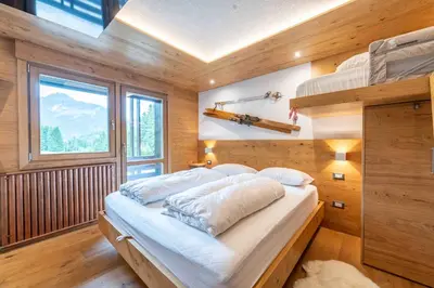 a bedroom with a bunk bed and a window at Cesa Ardon 1 in Campitello di Fassa