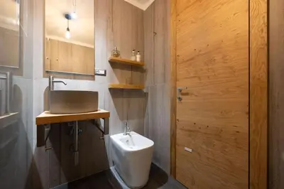 a bathroom with a sink and a urinal at Cesa Ardon 1 in Campitello di Fassa