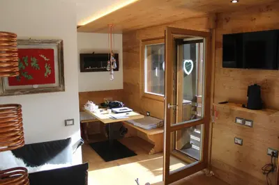 a room with a desk with a window and a television at Cesa Ardon 1 in Campitello di Fassa