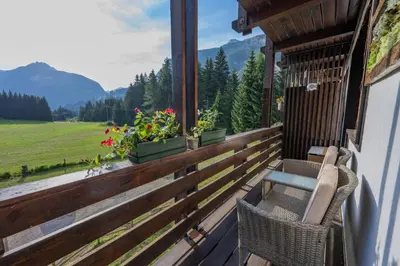 a balcony with chairs and flowers on a house at Cesa Ardon 1 in Campitello di Fassa