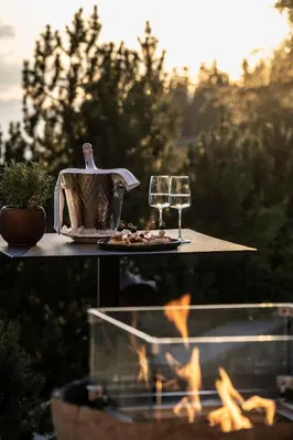 a table with a tea kettle and a glass of wine at Hotel Rosa Eco Alpine Spa in Alpe di Siusi