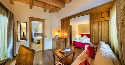 a living room with a couch and a bed at Hotel Rosa Eco Alpine Spa in Alpe di Siusi