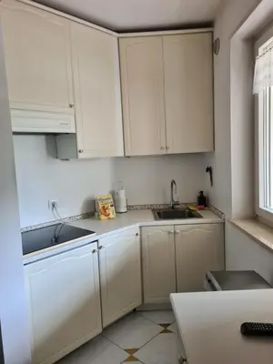 a kitchen with white cabinets and a sink at Villa Doris in Merano