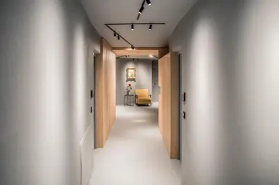 a hallway with white walls and wooden doors at Bettstadt Apartments in Vipiteno