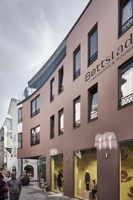 a building with people walking in front of it at Bettstadt Apartments in Vipiteno