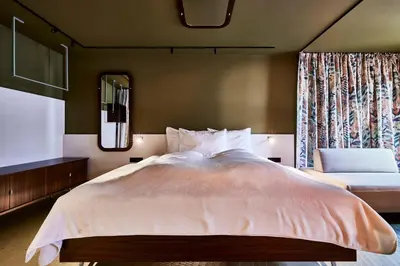 a bedroom with a large bed and a mirror at Bettstadt Apartments in Vipiteno