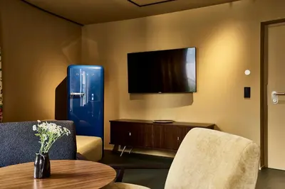 a living room with a tv and a table and chairs at Bettstadt Apartments in Vipiteno
