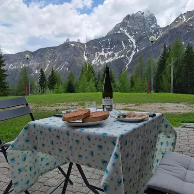 a table with a bottle of wine and food on it at La Casa degli Gnomi in Falcade
