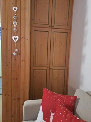 a room with a wooden cabinet with a red pillow at La Casa degli Gnomi in Falcade