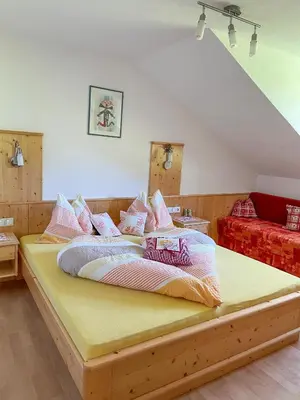a bedroom with a large bed with pink and white pillows at Kuenhof in San Sigismondo