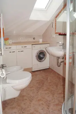 a bathroom with a toilet and a sink and a washing machine at Kuenhof in San Sigismondo