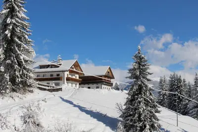 a ski lodge in the snow with trees at Bad Bergfallerhof in Valdaora