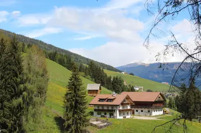 a house in the middle of a green hill at Bad Bergfallerhof in Valdaora