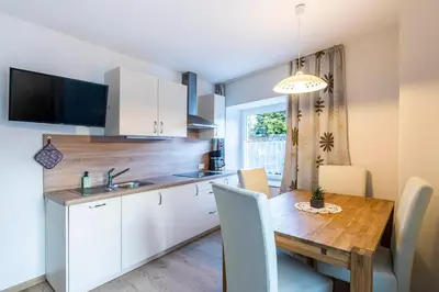 a kitchen and dining room with a wooden table and chairs at Residence Alpina in Tesimo