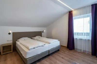 a bedroom with a bed and a large window at Residence Alpina in Tesimo
