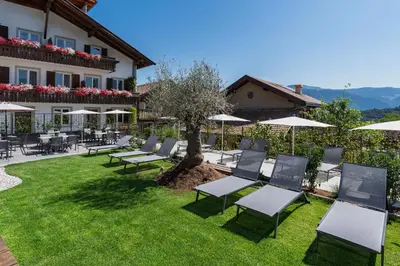 a group of chairs and umbrellas in a yard at Residence Alpina in Tesimo