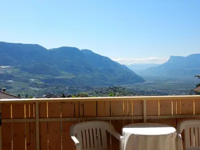 a table and chairs on a balcony with mountains at Garni-Hotel mir.es in Tirolo